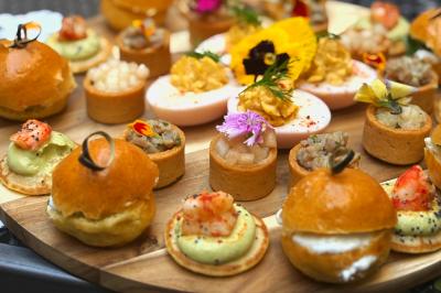 Miniature Traiteur Lyon 2 (Rhône) - Food And Beyond #30 Sandwiches colorés empilés avec des garnitures variées, entourés de roquette et d'olives vertes.