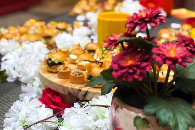 Sandwiches colorés empilés avec des garnitures variées, entourés de roquette et d'olives vertes.