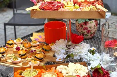 Sandwiches colorés empilés avec des garnitures variées, entourés de roquette et d'olives vertes.