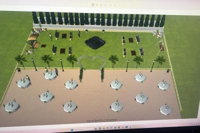 Vue aérienne d'un aménagement extérieur avec tables rondes, fontaine centrale, palmiers et espaces de détente.