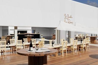 Vue aérienne d'un aménagement extérieur avec tables rondes, fontaine centrale, palmiers et espaces de détente.