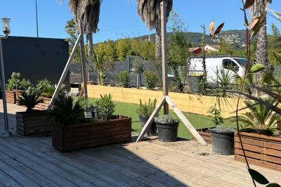 Vue aérienne d'un aménagement extérieur avec tables rondes, fontaine centrale, palmiers et espaces de détente.