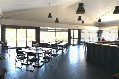 Vue aérienne d'un aménagement extérieur avec tables rondes, fontaine centrale, palmiers et espaces de détente.