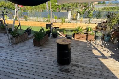 Vue aérienne d'un aménagement extérieur avec tables rondes, fontaine centrale, palmiers et espaces de détente.