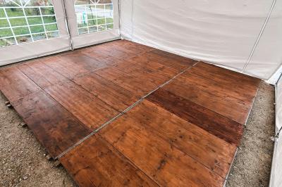 Tente beige éclairée par des guirlandes lumineuses, installée dans un jardin au coucher du soleil.