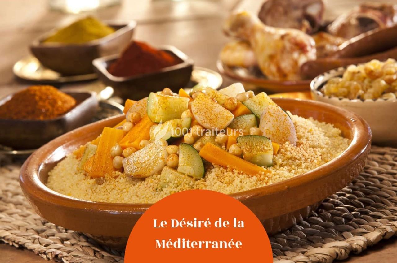 Plat de couscous garni de légumes variés, pois chiches et épices, présenté dans un plat en terre cuite.