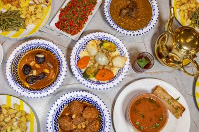 Miniature Traiteur Nanterre (Hauts-de-Seine) - Le Désiré de la Méditerranée #2 Bol de soupe garnie de coriandre sur une table en marbre avec des couverts, des verres et une salière en arrière-plan.