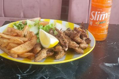 Miniature Traiteur Nanterre (Hauts-de-Seine) - Le Désiré de la Méditerranée #16 Bol de soupe garnie de coriandre sur une table en marbre avec des couverts, des verres et une salière en arrière-plan.