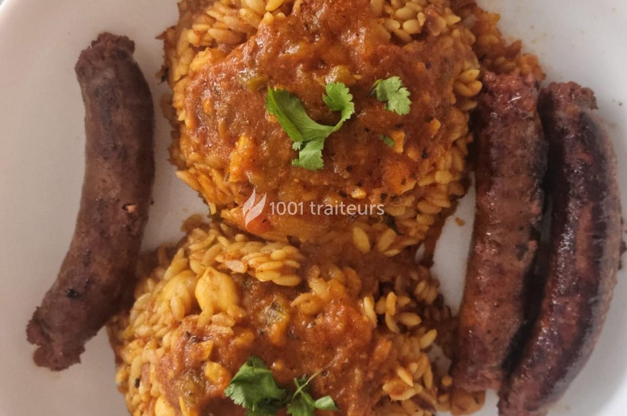 Assiette contenant deux portions de riz en sauce tomate garnies de coriandre, accompagnées de trois saucisses grillées.