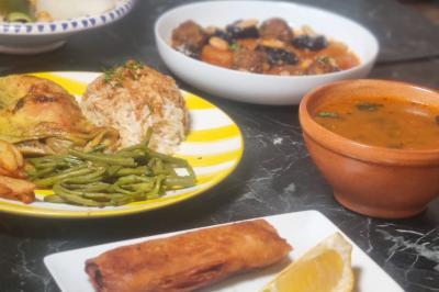 Miniature Traiteur Nanterre (Hauts-de-Seine) - Le Désiré de la Méditerranée #21 Bol de soupe garnie de coriandre sur une table en marbre avec des couverts, des verres et une salière en arrière-plan.