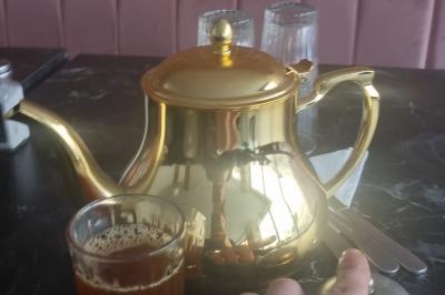 Miniature Traiteur Nanterre (Hauts-de-Seine) - Le Désiré de la Méditerranée #28 Bol de soupe garnie de coriandre sur une table en marbre avec des couverts, des verres et une salière en arrière-plan.