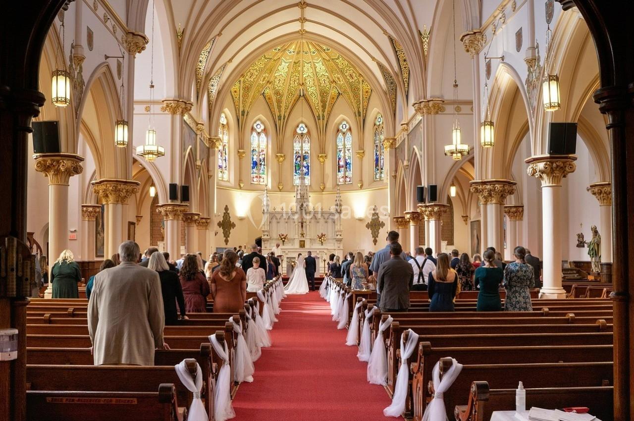 Cérémonie de mariage dans une église avec des invités assis, un couple avançant vers l'autel décoré.