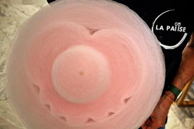 Miniature La Pause Barbe a Papa #3 Vue de dessus d'une barbe à papa rose tenue par une personne portant un t-shirt noir avec un logo blanc.