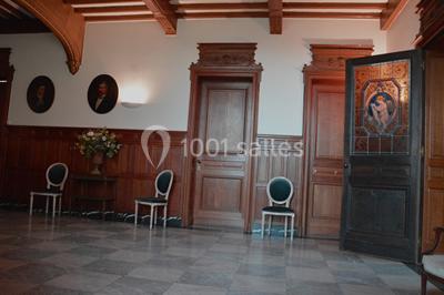 Miniature Location salle Uccle (Bruxelles-Capitale) - Domaine Allard #15 Vue d'une entrée avec porte en bois ouverte, sol en marbre, deux chaises et portraits accrochés sur des murs lambrissés.