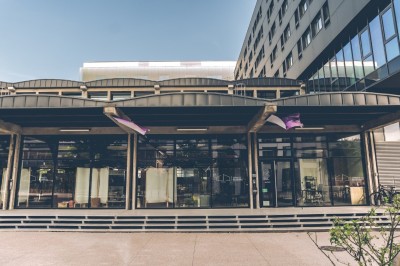 Salle sombre avec deux écrans affichant un paysage désertique, éclairages colorés et mobilier minimaliste.