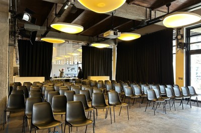 Salle sombre avec deux écrans affichant un paysage désertique, éclairages colorés et mobilier minimaliste.