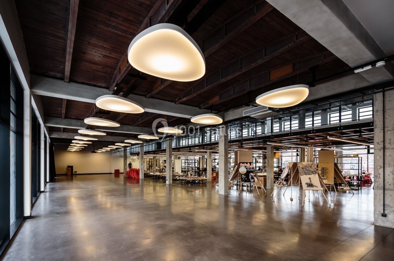 Espace intérieur moderne avec plafond en bois, luminaires suspendus et zones de travail ouvertes.