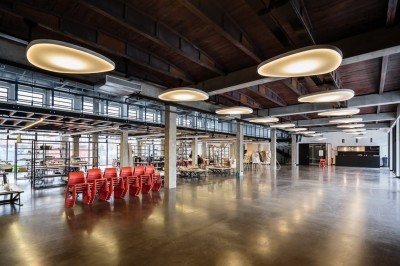 Salle sombre avec deux écrans affichant un paysage désertique, éclairages colorés et mobilier minimaliste.
