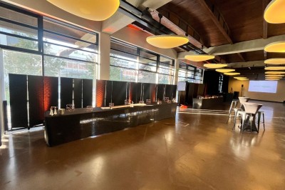 Salle sombre avec deux écrans affichant un paysage désertique, éclairages colorés et mobilier minimaliste.