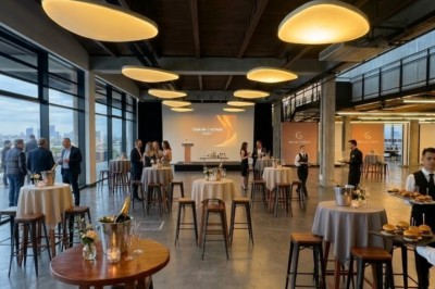 Façade vitrée d'un bâtiment moderne avec des drapeaux suspendus et une entrée visible au rez-de-chaussée.