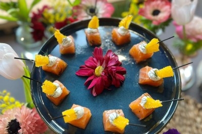 Plateau de bouchées apéritives garnies de mousse rose et décorées de feuilles de persil, disposées sur une grille.