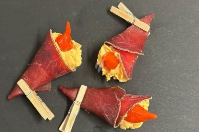 Plateau de bouchées apéritives garnies de mousse rose et décorées de feuilles de persil, disposées sur une grille.