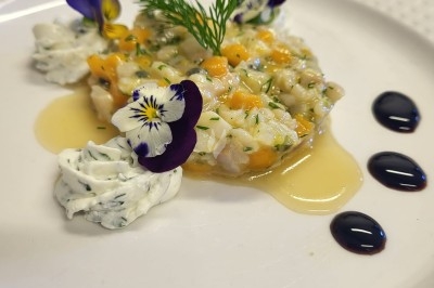 Plateau de bouchées apéritives garnies de mousse rose et décorées de feuilles de persil, disposées sur une grille.