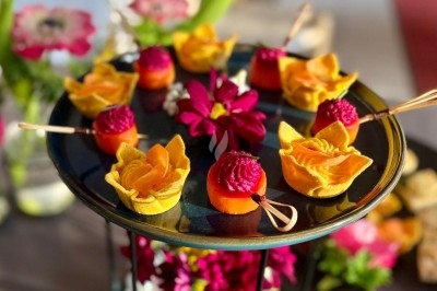 Plateau de bouchées apéritives garnies de mousse rose et décorées de feuilles de persil, disposées sur une grille.
