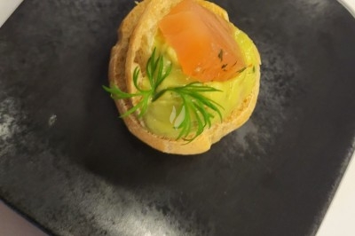 Plateau de bouchées apéritives garnies de mousse rose et décorées de feuilles de persil, disposées sur une grille.