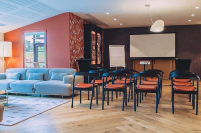 Vue aérienne d'une terrasse animée entourée de vignes au coucher du soleil, avec des invités profitant du cadre.