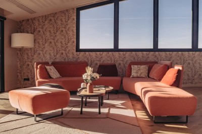 Vue aérienne d'une terrasse animée entourée de vignes au coucher du soleil, avec des invités profitant du cadre.