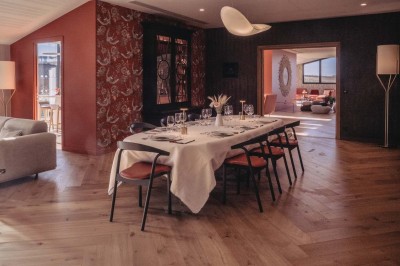 Vue aérienne d'une terrasse animée entourée de vignes au coucher du soleil, avec des invités profitant du cadre.