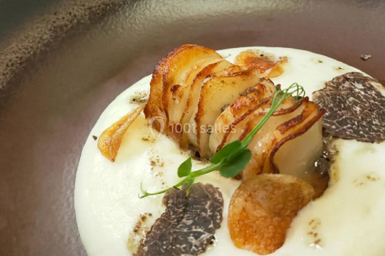 Purée onctueuse garnie de tranches de pommes de terre croustillantes, truffes et herbes fraîches.