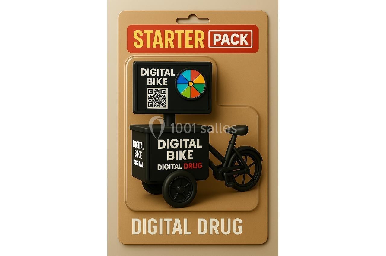 Figurine miniature d'un vélo avec écran et QR code, présentée dans un emballage marqué ’Starter Pack’ et ’Digital Drug’.