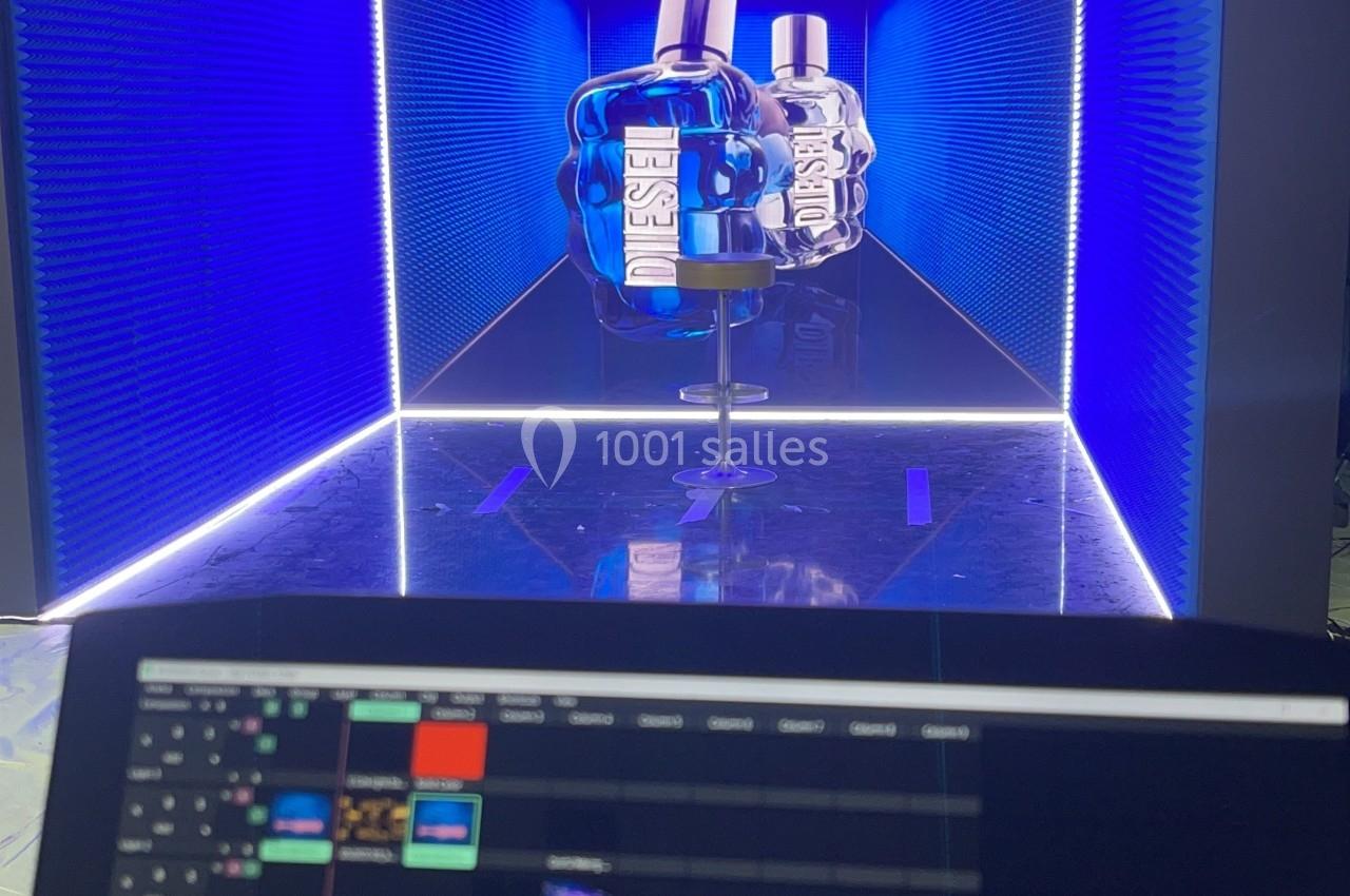 Vue d'un écran de contrôle affichant une scène lumineuse en cube bleu avec des objets au centre.