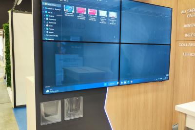 Conférence avec un orateur sur scène, éclairages colorés et public assis dans une salle équipée de projecteurs.