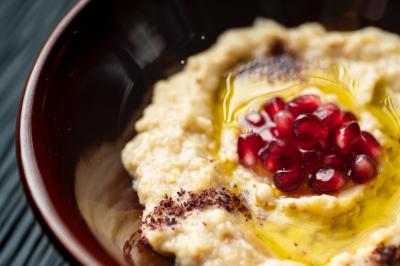 Assortiment de mezzés libanais sur une planche en bois, incluant falafels, samoussas, rouleaux et chaussons.