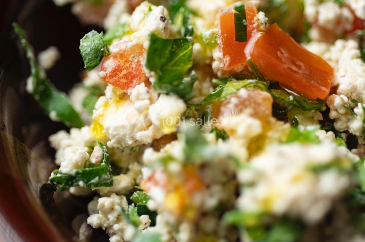 Salade composée de fromage frais, tomates, herbes fraîches et huile d'olive dans un bol en céramique.