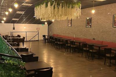 Miniature Location salle Saint-Soupplets (Seine-et-Marne) - The Taj #2 Salle moderne avec écran affichant des cœurs lumineux, tables et chaises noires, plafond décoré de fleurs suspendues.