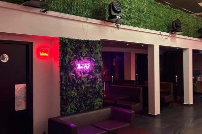 Miniature Location salle Saint-Soupplets (Seine-et-Marne) - The Taj #4 Salle moderne avec écran affichant des cœurs lumineux, tables et chaises noires, plafond décoré de fleurs suspendues.