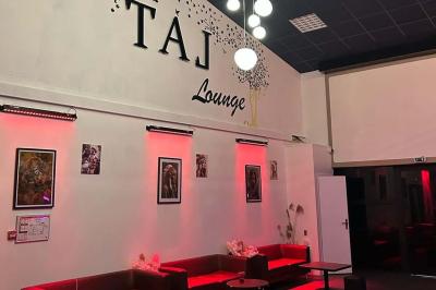 Miniature Location salle Saint-Soupplets (Seine-et-Marne) - The Taj #6 Salle moderne avec écran affichant des cœurs lumineux, tables et chaises noires, plafond décoré de fleurs suspendues.