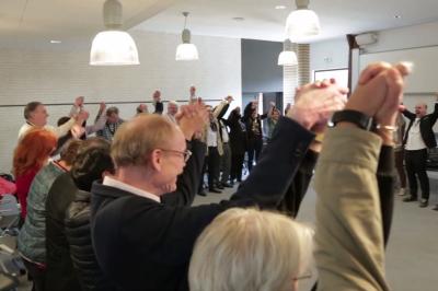 Miniature Théâtre Moderne #7 Un groupe de personnes souriantes rassemblées dans une ambiance conviviale lors d'un événement en intérieur.