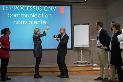 Miniature Théâtre Moderne #11 Un groupe de personnes souriantes rassemblées dans une ambiance conviviale lors d'un événement en intérieur.