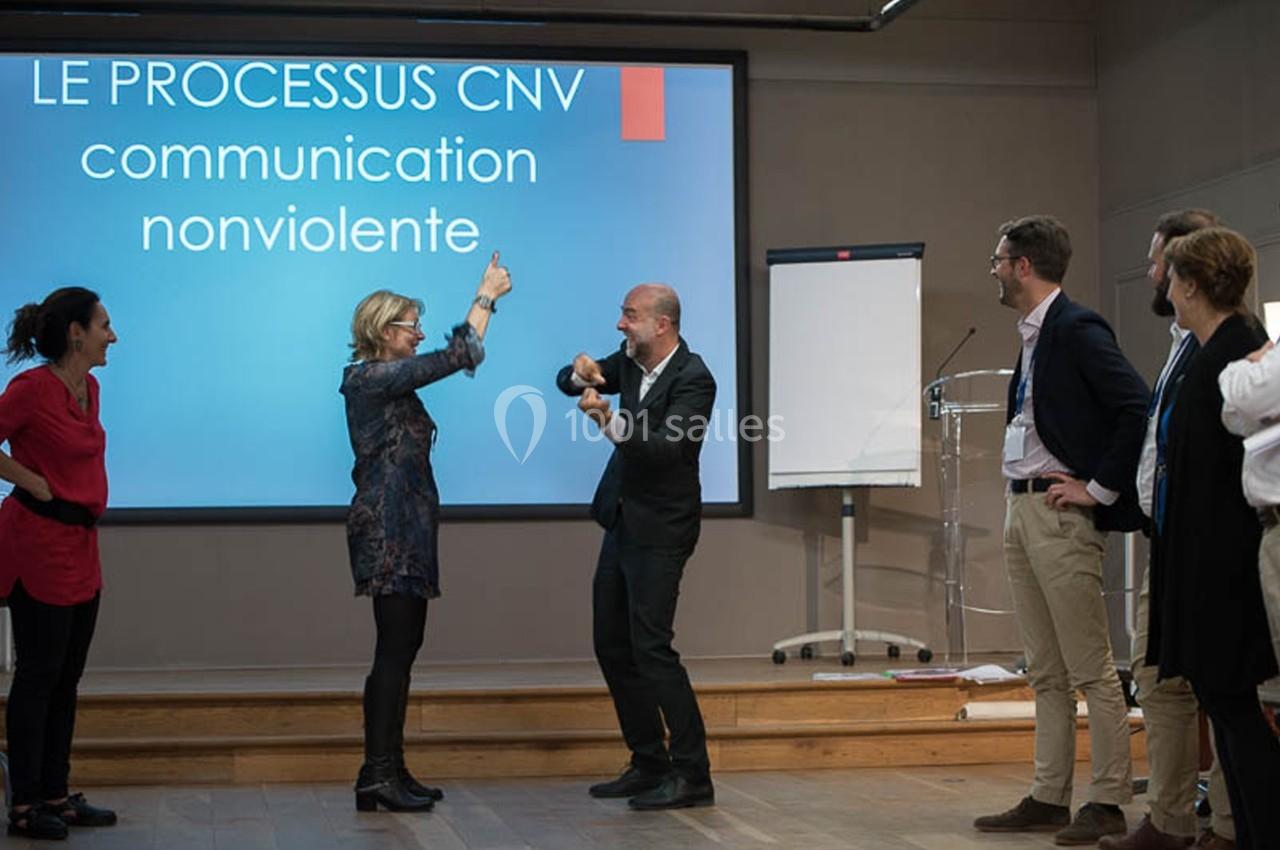 Un groupe de personnes participe à un atelier sur la communication non violente, avec une présentation projetée.