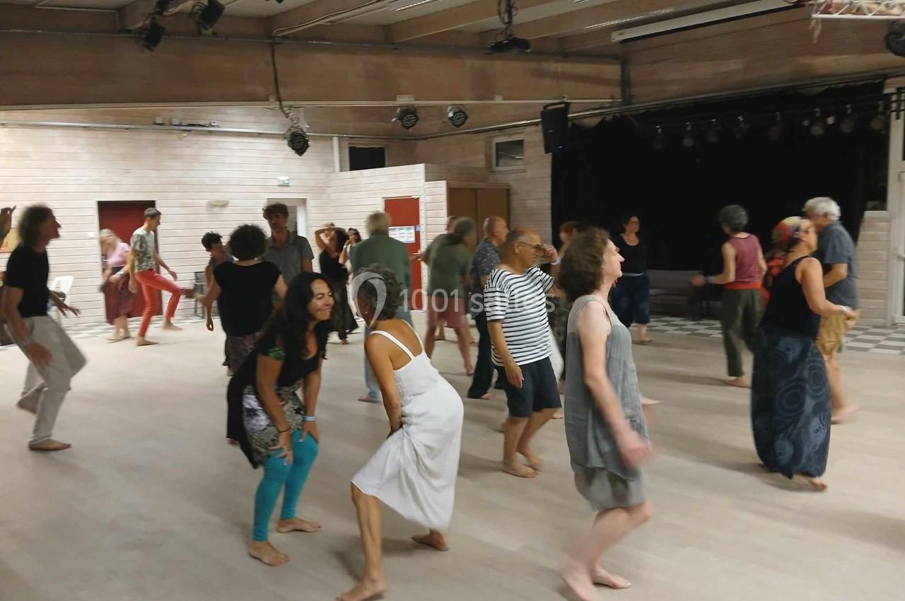 Personnes dans une salle lumineuse participant à une activité de danse ou de mouvement collectif.