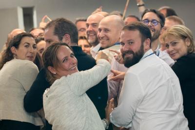 Miniature Théâtre Moderne #20 Un groupe de personnes souriantes rassemblées dans une ambiance conviviale lors d'un événement en intérieur.