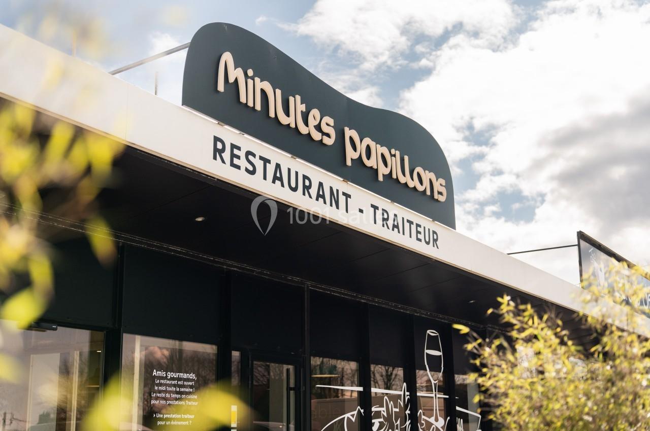 Façade d'un restaurant-traiteur nommé ’Minutes Papillons’, avec une enseigne visible sous un ciel partiellement nuageux.
