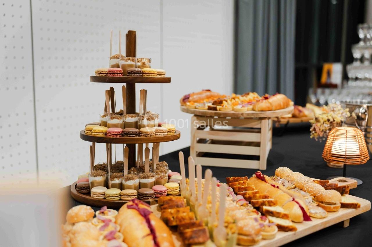Plateau de desserts variés comprenant macarons, pâtisseries et gâteaux, disposés sur une table lors d'un buffet.