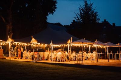 Miniature Location salle Namur (Namur) - Château de Beez #18 Dîner en plein air sous des guirlandes lumineuses, avec des invités assis autour de tables éclairées au crépuscule.