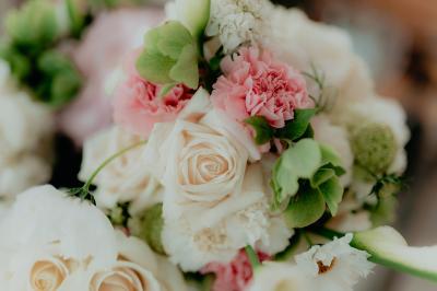 Un couple souriant marche main dans la main au milieu d'invités applaudissant lors d'une cérémonie en plein air.